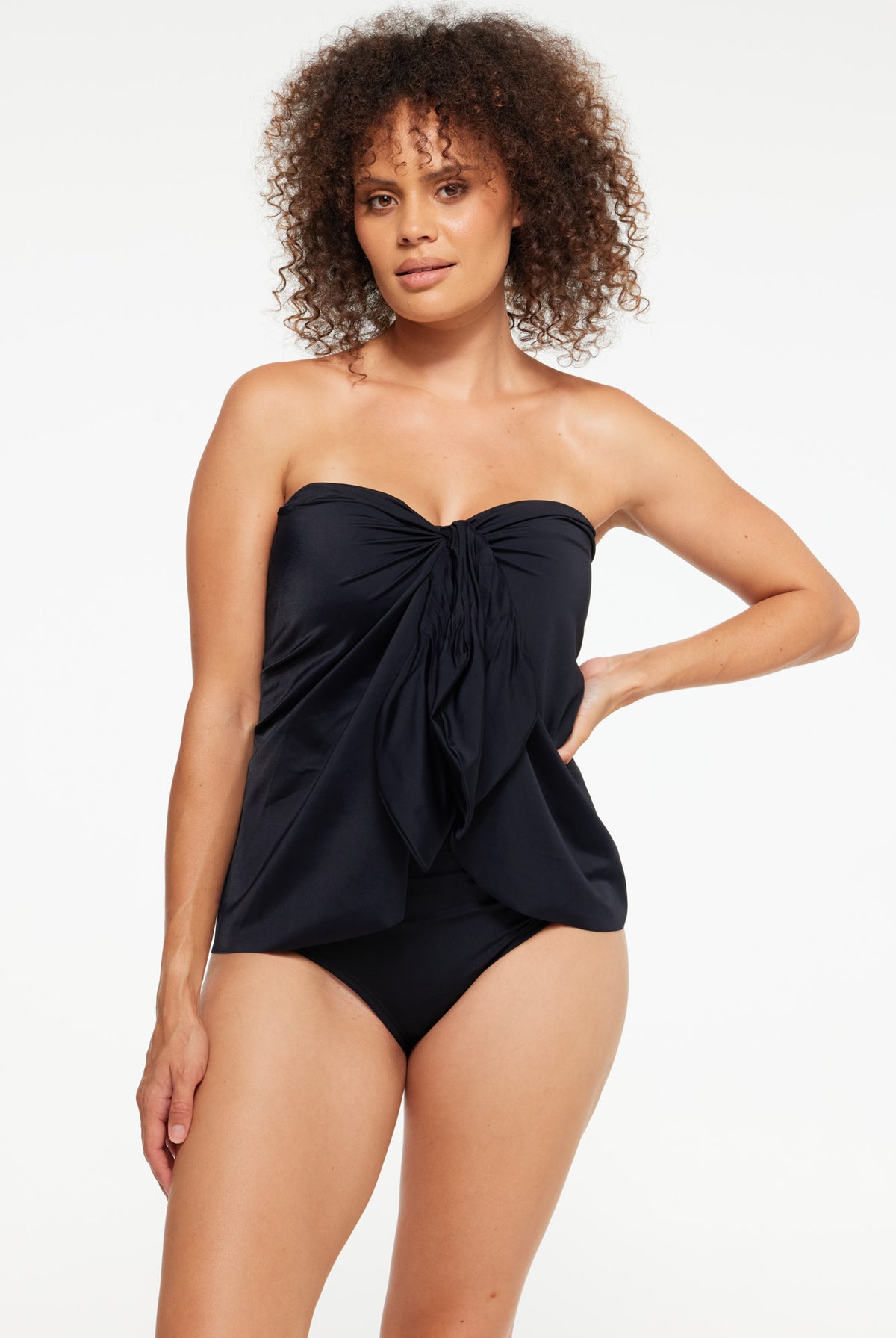 Woman wearing a black strapless swimdress overlay with tie front detail
