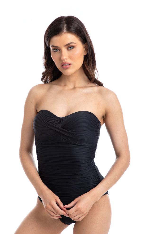 Woman wearing a black ribbed texture bandeau one piece swimsuit, worn strapless